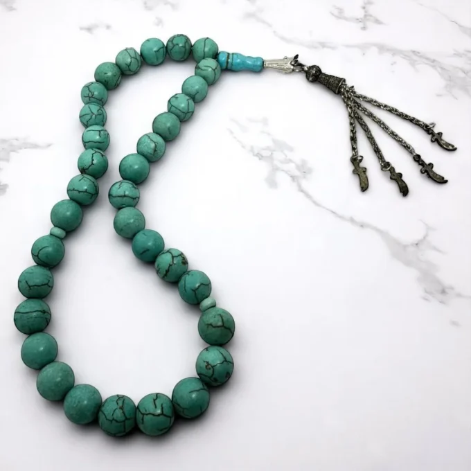 furuze (turquiose)tesbeh with silver chain on marble surface